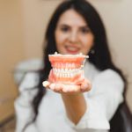 patient holding a full denture model during consultation