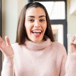 patient holding clear invisalign aligners before starting teeth straightening treatment