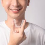 patient holding clear aligner for orthodontic treatment